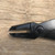 Side profile of the Tinyroots carbon steel jin pliers on weathered wood