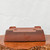 An accessible and descriptive alt text for this image would be:

"A large, unglazed Yixing bonsai pot, measuring 15 inches, is shown upside down to display its structural details. The pot is crafted from a smooth, matte, reddish-brown clay and has a sturdy rectangular shape. Positioned on its rim, the underside reveals four substantial integrated corner feet, two large circular drainage holes, and four smaller holes for securing bonsai wire. The pot rests on a polished, natural-edged wooden burl slab against a plain white background, highlighting its traditional craftsmanship and functional design."