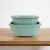 Celadon green glazed Japanese bonsai pots in small and large, nested together on an oak shelf