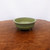 7 inch round Yixing succulent dish on a reddish brown burl tabletop