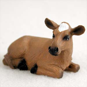 A detailed miniature Guernsey cow figurine, designed as a decorative accessory for a bonsai tree arrangement. The tan-brown cow is shown in a resting position, laying down with its legs tucked underneath. It features realistic details, including a prominent white patch on its forehead, a black muzzle, and dark hooves. This small, lifelike figurine is intended to add a charming farm-themed element to a miniature garden or bonsai display.