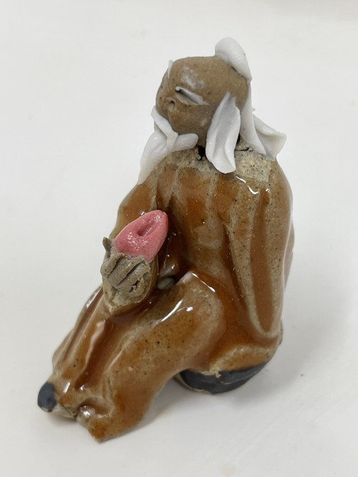 Chinese Figurine - Man on orange Log holding Shell (F-005)