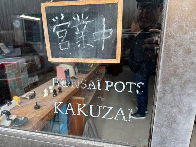 Kakuzan Toen Tokoname kiln window showing Bonsai Pots Kakuzan lettering and Japanese characters on a chalkboard sign