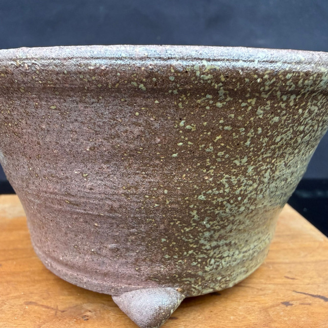 Close-up of Kakuzan Tokoname bonsai pot showing rustic brown speckling, surface texture, and foot detail