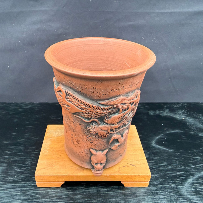 Angled front view of Kouji Watanabe Tokoname tall bonsai pot showing dragon carving wrapping the body and flared rim