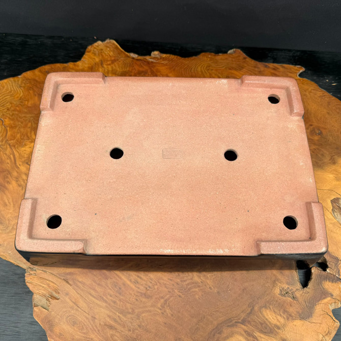 Bottom view showing foot layout, drainage holes, and the artist stamp