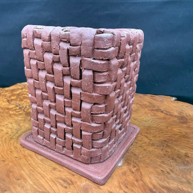 Angled side view of hand-built woven clay accent pot showing basket texture
