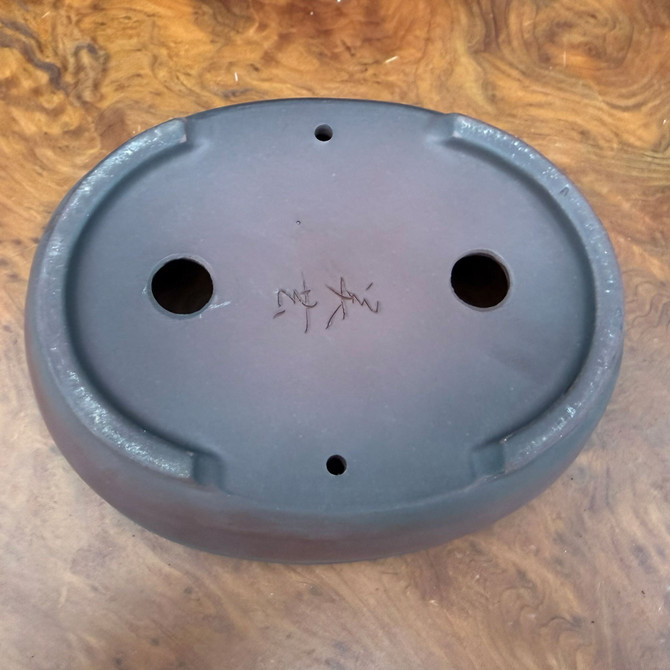 Bottom view of 6.25 inch Bigei Tokoname oval bonsai pot showing feet, drainage holes, and Bigei signature