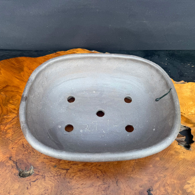 Top view of handmade oval bonsai pot showing unglazed interior and drainage holes