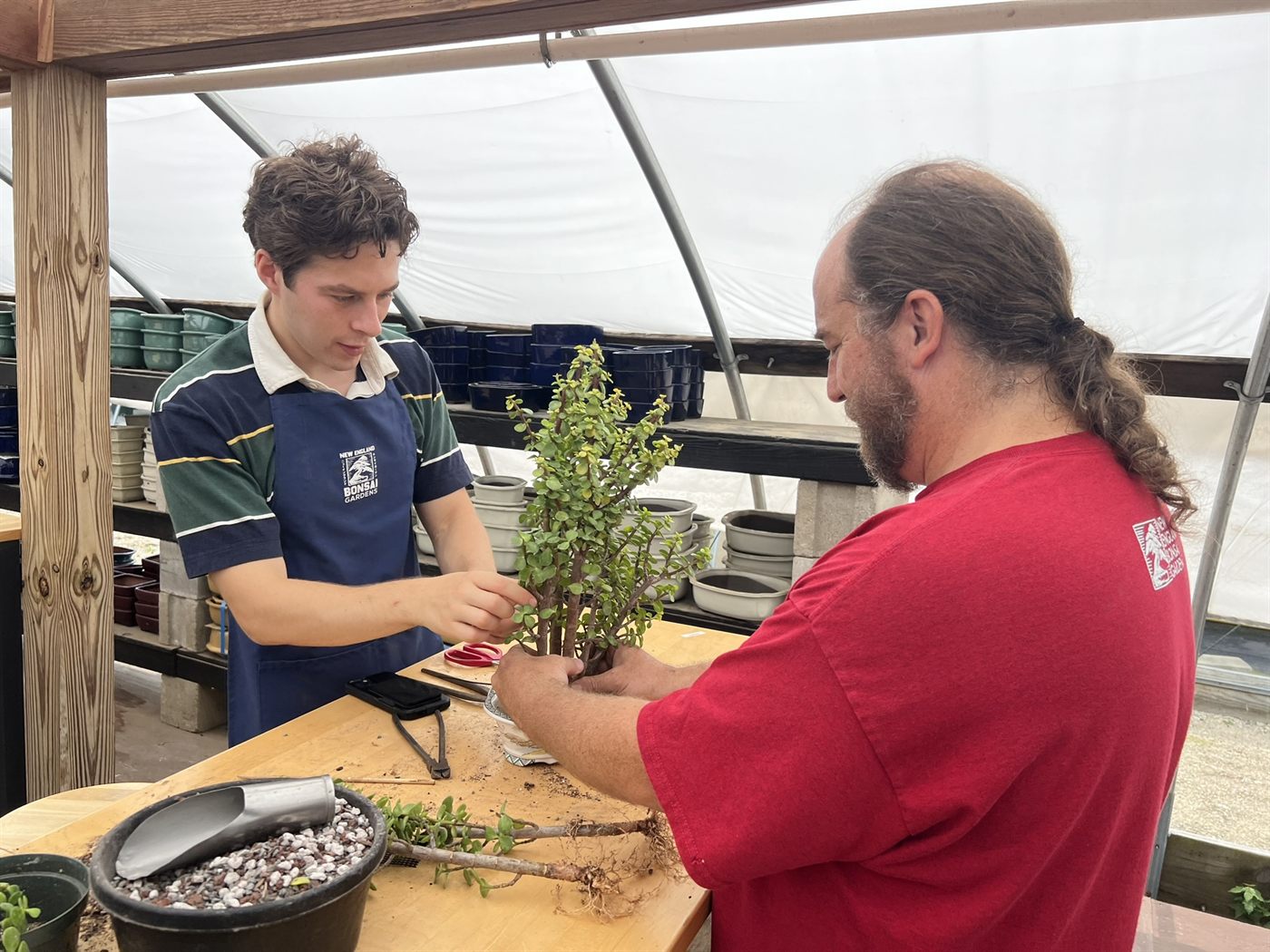 Jamie Prevosk working through a tree with a student at the potting bench