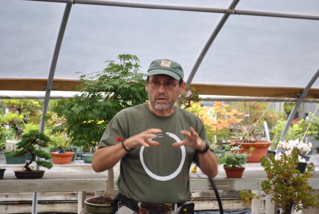John Romano teaching in the greenhouse, gesturing as he explains a technique