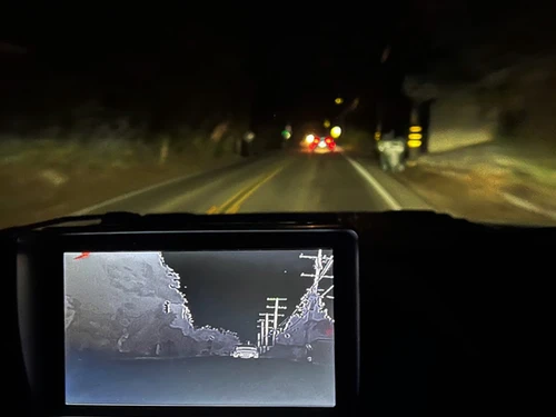 Night Owl HD thermal camera view on a dash screen while driving at night
