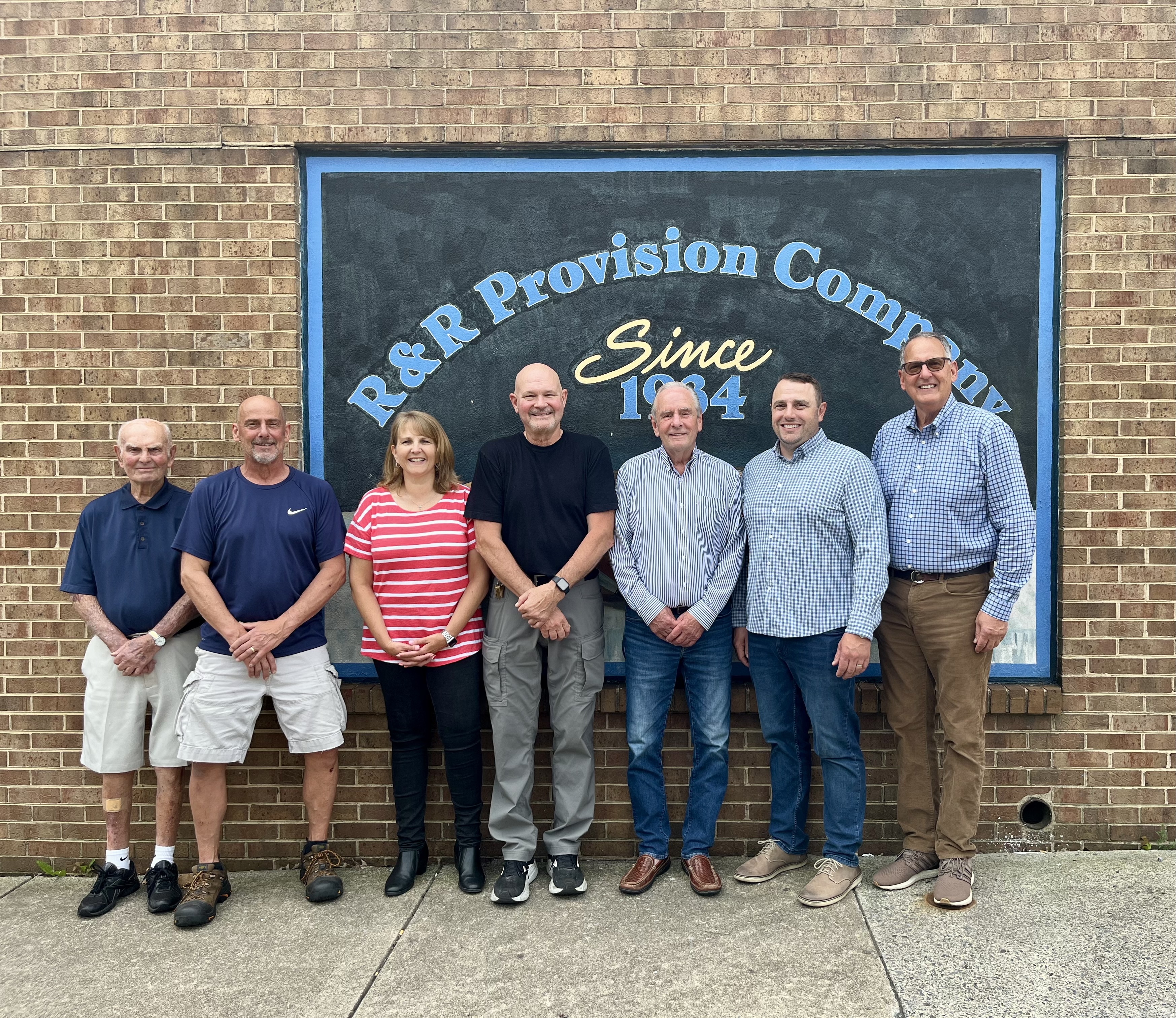 R&R Provision Co Management standing in front of company trucks