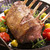 Elk rib rack cooked on a plate with tomatoes and potatoes