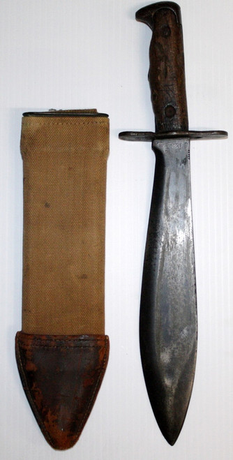 original WWI US Model 1917 bolo knife that is maker marked ���������PLUMB PHILA.��������� on the left side of the blade and dated 1918. Right side of blade is marked ���������U.S. MOD. 1917���������.  Wood grips have original finish and a good tight fit. Fitted in correct original scabbard where the Canvas shows wear and staining. Leather tip is dry. A nice example of a classic WWI US Model 1917 bolo knife for your collection.