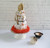 A mushroom printed kitchen towel cake with orange shred and wooden utensils protruding from the top.