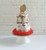A mushroom printed kitchen towel cake with orange shred and wooden utensils protruding from the top.