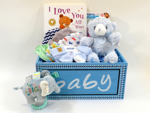 Baby boy gift basket features adorable plush blue teddy bear, rattle and baby essentials.