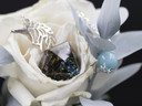 Unicorn Magic Pendulum resting on white flower petals, showcasing teal Czech glass and aquamarine dangle