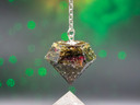 Radiant Soul pendulum with carnelian bead and tree of life charm displayed on a crystal background.