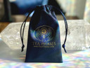 Navy drawstring flannel jewelry pouch with a metallic gold Tea Phases logo imprinted.