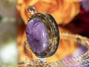 Side view of amethyst tea-infused pendant showing layered eco resin and botanical infusion