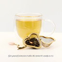 Brewed Mindful Green loose-leaf sencha green tea with a golden infusion and tea infuser.