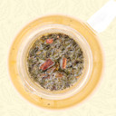 Steeped Mindful Green sencha green tea leaves and natural vanilla bean pieces in a glass teapot.