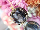 Handcrafted Hypersthene tea pendant featuring a dark reflective gemstone, Goddess Grey tea botanicals and gold details.