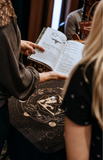 Intuitivitea tea casting guidebook and divination cloth being used during a personalized intuitive reading by Tea Phases.