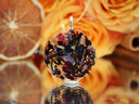 Back of I See Beyond the Veil pendant featuring black tea leaves and colorful botanicals preserved in clear resin.