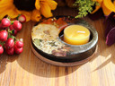 Angled view of botanical resin candle holder with beeswax tealight, pressed autumn flowers, Pyrite and Shungite on cork.