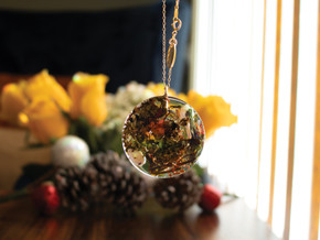 Profile view of a handcrafted 14k gold-filled round pendant infused with a raw marialite stone, green tea, and jasmine and saffron herbs in eco resin. Hanging from a 16" 14k gold-filled chain. Profile view of a handcrafted 14k gold-filled round pendant infused with a raw marialite stone, green tea, and jasmine and saffron herbs in eco resin. Hanging from a 16" 14k gold-filled chain.