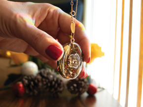 Handcrafted 14k gold-filled round pendant infused with a raw marialite stone, green tea, and jasmine and saffron herbs in eco resin. Hanging from a 16" 14k gold-filled chain. Handcrafted 14k gold-filled round pendant infused with a raw marialite stone, green tea, and jasmine and saffron herbs in eco resin. Hanging from a 16" 14k gold-filled chain.