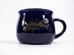 Close-up angled view of royal blue Witches Brew mug with matte gold design, crescent moon, stars, and Labradorite accents. Close-up angled view of royal blue Witches Brew mug with matte gold design, crescent moon, stars, and Labradorite accents.