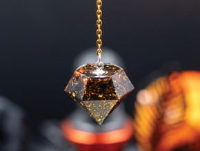 Handcrafted pendulum with saffron petals, gold accents, and black tea leaves in resin. A radiant tool for clarity, divination, and solar energy.