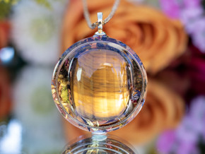 Close-up of I AM Successful pendant featuring AAA Tiger’s Eye set in gold ring with tea botanicals in resin