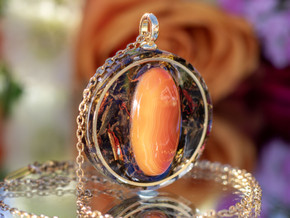 Side view of round agate pendant showing layered eco resin and botanical infusion