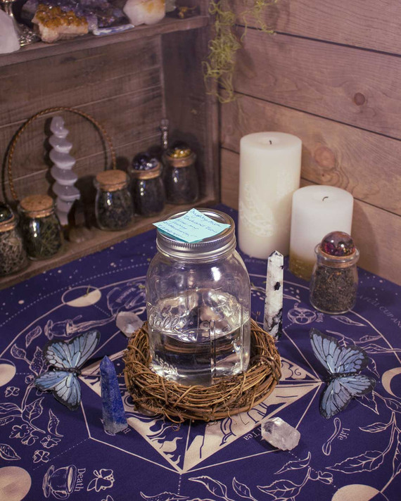 Moon Phase Ritual on Altar – Lit candle and ritual elements placed on an altar setting with the casting cloth.