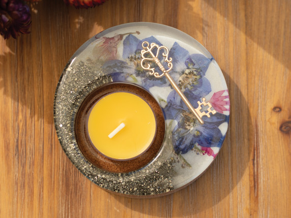 Overhead view of the Light Secret Garden Candle Holder featuring vibrant blossoms, golden key, and sparkling pyrite details surrounding a yellow tealight.