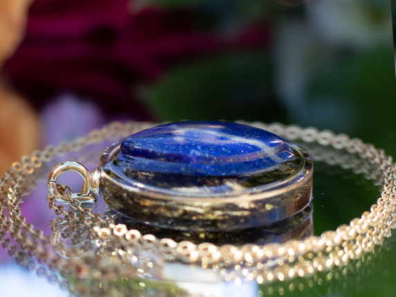 Side view of sodalite tea-infused pendant showing layered eco resin and botanical infusion