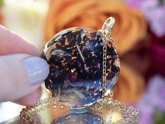 Back view of black tea leaves and botanicals suspended in clear resin