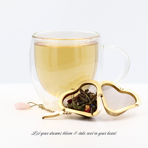 Cup of brewed Spring Blossom white tea with a loose-leaf tea infuser