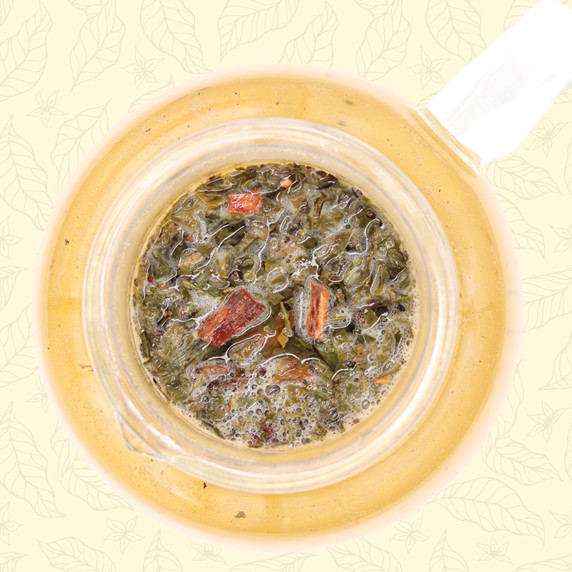 Steeped Mindful Green sencha green tea leaves and natural vanilla bean pieces in a glass teapot.