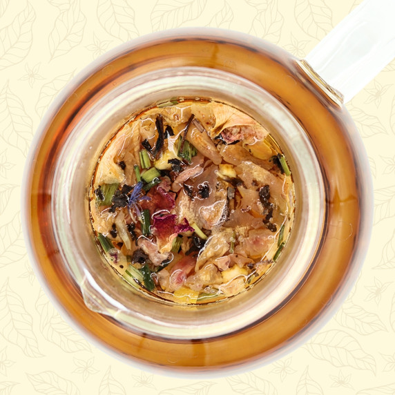 Goddess Grey black tea steeping in a glass teapot with colorful rose, cornflower, citrus and lemongrass visible.