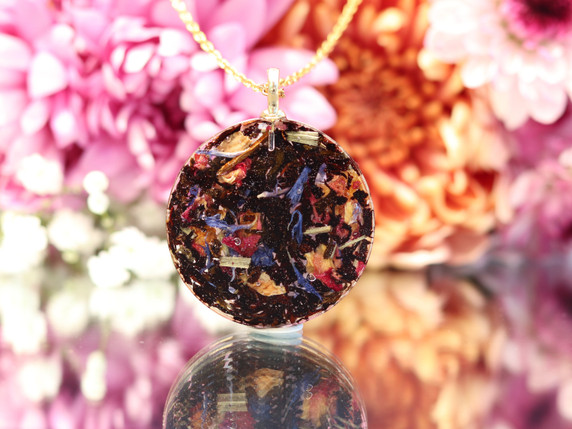 Back of a Hypersthene pendant handcrafted with colorful Goddess Grey black tea botanicals preserved in resin.