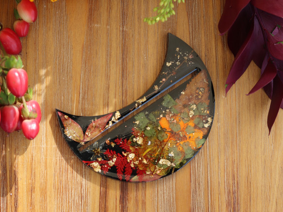 Front view of Autumn Alchemy crescent-shaped tarot card holder with orange and red pressed botanicals and metallic leaf.