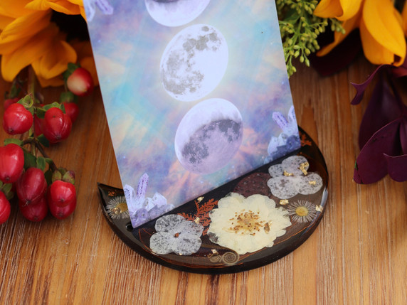 Handmade botanical tarot card holder displaying an oracle card among pressed flowers, metallic leaf and autumn floral styling.