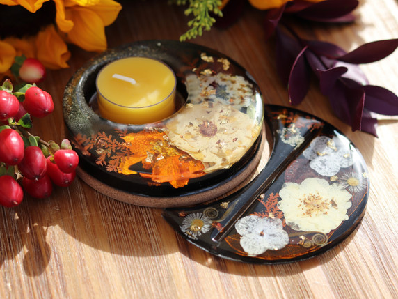 Matching handmade botanical candle holder and tarot card holder with cream and orange pressed flowers and metallic leaf.