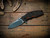 Assembly Special-Jurassic-Slicer Hollow Ground-Magnacut-Stonewash Purple-Orange/Black G10-Black Nitride Hardware/Orange Standoff-Scale Side